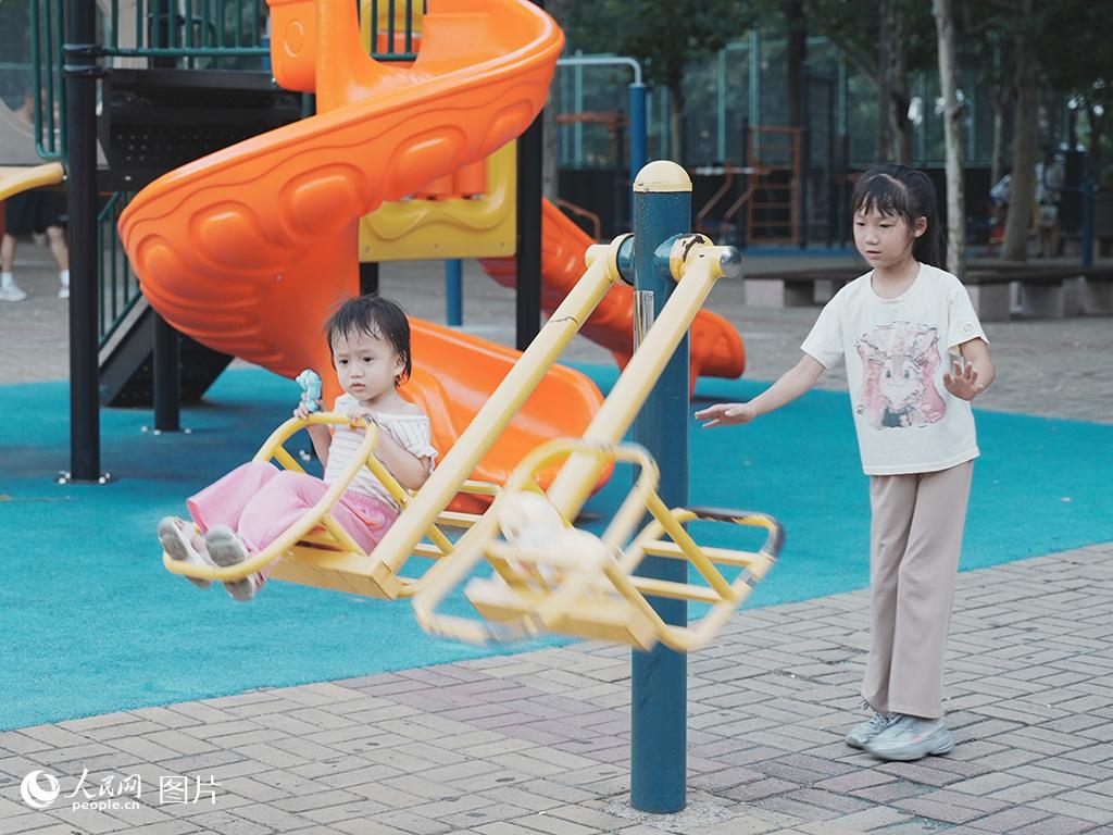 8月6日下午，河北秦皇岛经济技术开发区的小朋友在口袋公园里的健身设施上玩耍。人民网 席彪摄