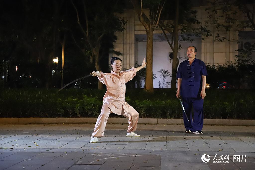 8月6日，广东广州，珠江畔步道上，武术师傅指导学生练习舞剑。人民网 杨健楠摄