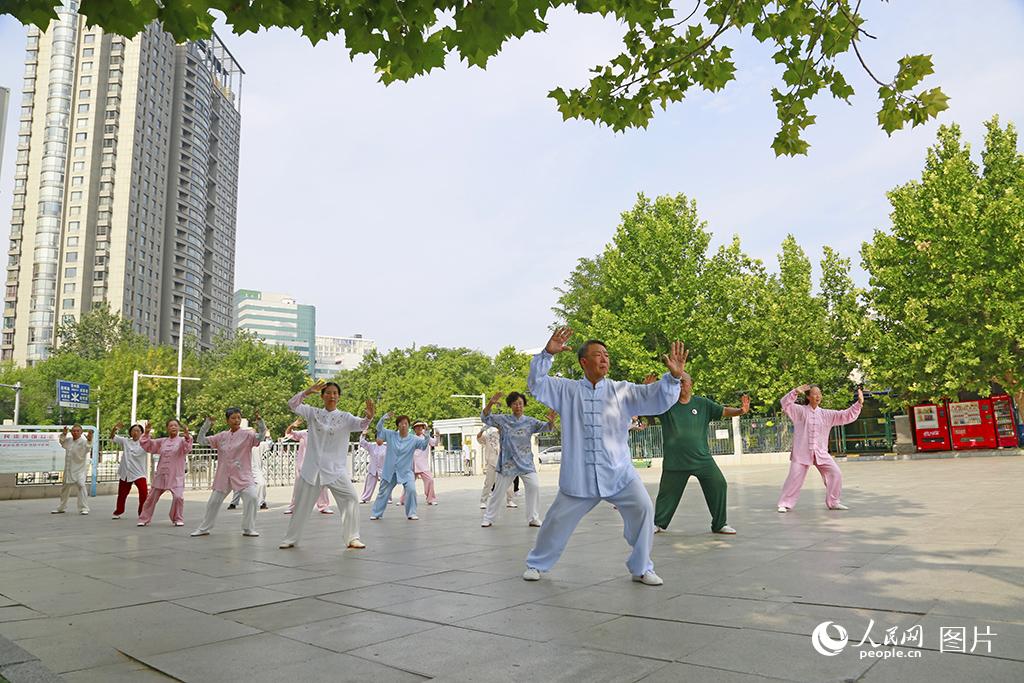 8月6日，天津市人民体育馆前广场，健身爱好者正在习练传统杨氏太极拳，一招一式尽显传统韵味。人民网记者 崔新耀摄