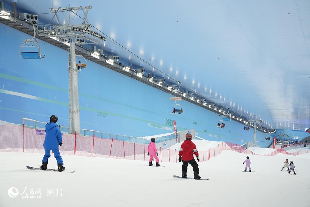 8月2日，吉林长春的大型室内滑雪场上演着冰雪运动的欢乐。盛夏与冰雪碰撞，游客纵情驰骋雪道，尽享反季滑雪带来的畅快体验。人民网记者 李洋摄 (2)